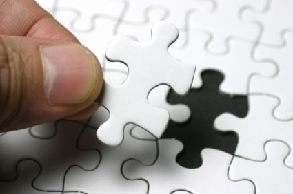 person placing jigsaw puzzle piece
